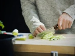 Fiskars Norr Santoku Knife -Kitchenware Shop Fiskars Kitchen Action Norr Santoku knife cutting celery 1016474